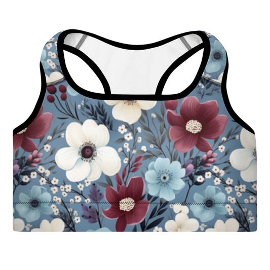 A sports bra with a butterfly garden print, predominantly blue with red and white flowers, and a scoop neckline.