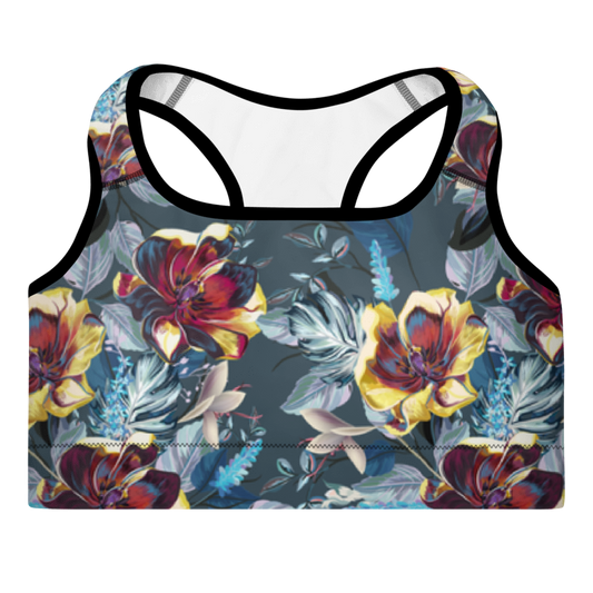 A sports bra with a floral pattern in shades of red, blue, and green on a black background, featuring a scoop neckline and racerback design.